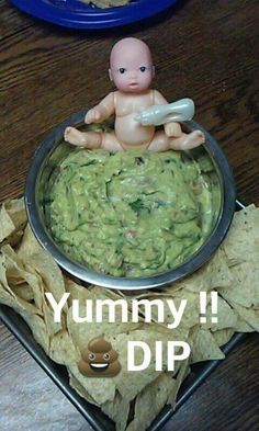 a bowl filled with guacamole and chips on top of a wooden table