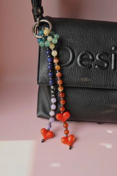 a black purse with some beads hanging from it