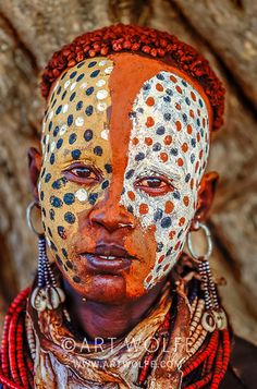 an african woman with painted face and headdress