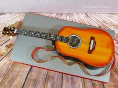 an acoustic guitar in a gift box on a wooden floor