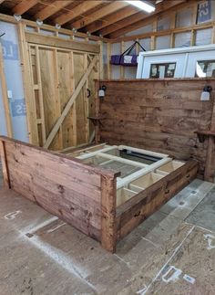 an unfinished bed frame in the middle of a room with wooden walls and flooring