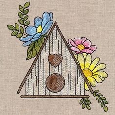 a birdhouse with flowers and two hearts on the outside is embroidered onto it's side