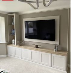 a large flat screen tv mounted to the side of a wall in a living room