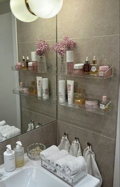 a bathroom sink sitting under a mirror next to a shelf filled with personal care items