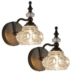 two lights that are on the side of a wall mounted fixture with clear glass shades