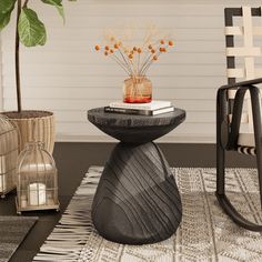 a black table sitting on top of a rug next to a chair and potted plant