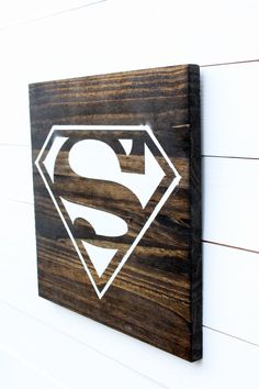 a wooden sign with a superman symbol on it