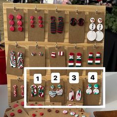 a display case with christmas themed earrings and other items on it, along with the numbers 1 - 4