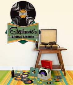 there is a record player on the floor next to a table with records and other items