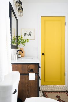 a bathroom with yellow door and white sink