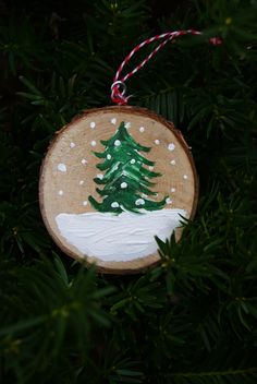 a wooden ornament with a christmas tree painted on it