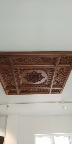 the ceiling in this room is decorated with intricate woodwork and decorative carvings on it