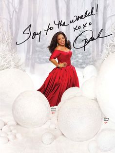 a woman in a red dress posing for a photo with snow balls around her and the words joy to the world on it