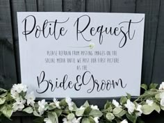 a sign that says polite request on the side of a fence with flowers around it