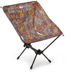 a small folding chair with an orange and blue flower pattern on it's back