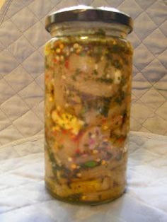 a jar filled with food sitting on top of a white tablecloth covered floor next to a metal lid