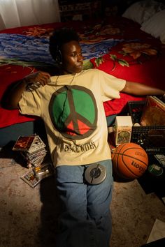 a person sitting on the floor with headphones in their ears next to a basketball