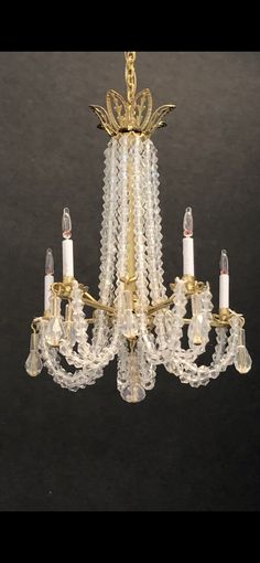 a chandelier with many lights hanging from it's sides and two candles in the middle