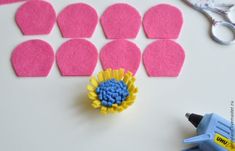 a pair of scissors next to some felt pieces and glue on a white surface with pink circles