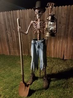 a skeleton is holding a shovel and standing in front of a fence with a lantern