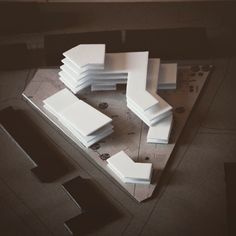 an aerial view of a building made out of white blocks and pieces of cardboard on the floor