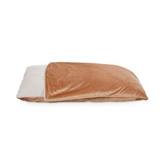 a brown and white dog bed with a pillow on the bottom, in front of a white background