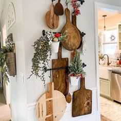 several wooden cutting boards mounted to the wall with plants and potted plants on them