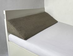 a close up of a bed with a pillow on it's headboard and mattress