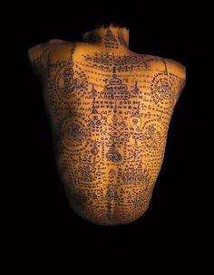 the back of a man's body is covered in intricately designed writing and ink