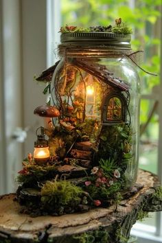 a jar filled with plants and lights on top of a wooden table next to a window