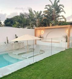 an outdoor swimming pool surrounded by lush green grass