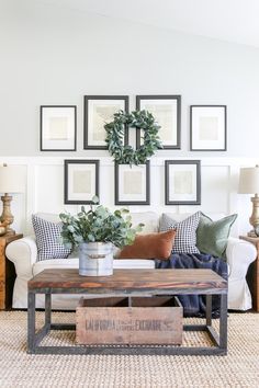 a living room with pictures on the wall and a coffee table in front of it