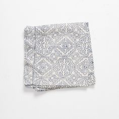 a white and blue patterned pocket square on a white surface