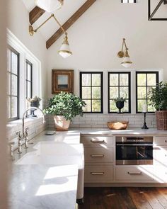 a kitchen with an oven, sink and windows in the ceiling above it is also a wood floor