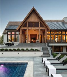 a house with a pool in front of it and stairs leading up to the upper floor