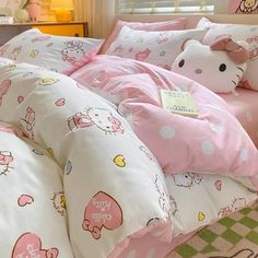 a hello kitty bed set with pink and white comforter, pillowcases and pillows