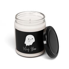 a white candle with a black lid sitting next to it