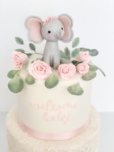 there is a cake decorated with pink flowers and an elephant on top