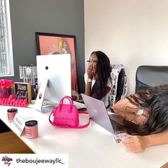 a woman laying on her back in front of a desk with a laptop and pink purse