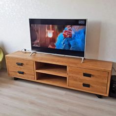 a flat screen tv sitting on top of a wooden entertainment center