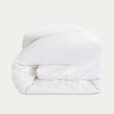 an unmade bed with white sheets and pillows