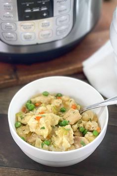 a white bowl filled with pasta and peas next to an instant pot pressure cooker