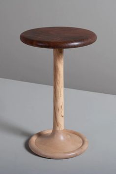 a small wooden table sitting on top of a gray surface