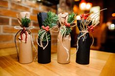 three wine bottles wrapped in brown paper and tied with twine, are sitting on a table