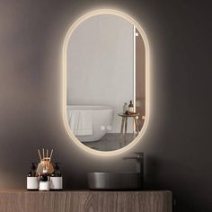 a bathroom with a round mirror on the wall next to a sink and bathtub