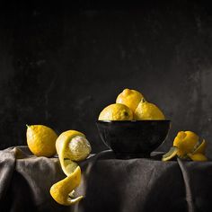 a bowl filled with lemons sitting on top of a table