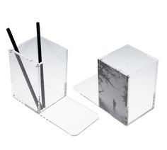 two clear boxes with black and white designs on the sides, one has a pen in it