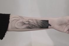 a woman's arm with a tattoo on it that has a bird in the middle