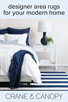 a white bed sitting next to a blue and white rug