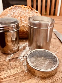 a loaf of bread sitting on top of a wooden table next to two salt shakers